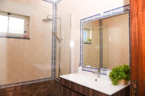 a bathroom with a sink and a shower with a mirror at The Quiet Loft Praia d'el Rey Golf Resort in Amoreira