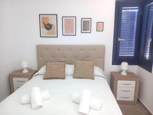 a bedroom with a bed with white sheets and pillows at Los Barqueros 25 by Best Holidays Fuerteventura in Corralejo