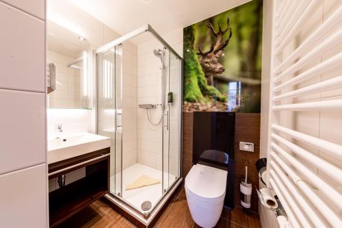 a bathroom with a shower and a toilet and a sink at Ringhotel Jägerhof in Weißenfels