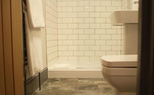 a white bathroom with a toilet and a shower at The Cross at Croscombe in Wells