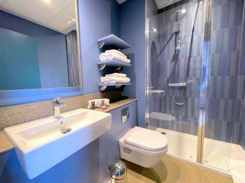 a bathroom with a sink and a toilet and a shower at Hex Wildlife Hotel at Yorkshire Wildlife Park in Doncaster