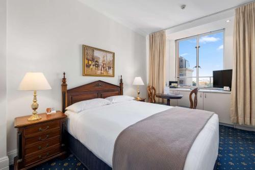 een hotelkamer met een bed en een groot raam bij Castlereagh Boutique Hotel, Ascend Hotel Collection in Sydney