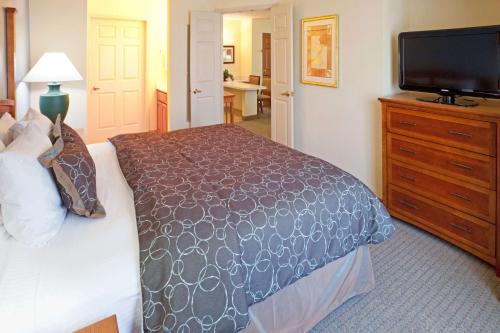 a bedroom with a bed and a flat screen tv at Sonesta ES Suites Dallas - Las Colinas in Irving