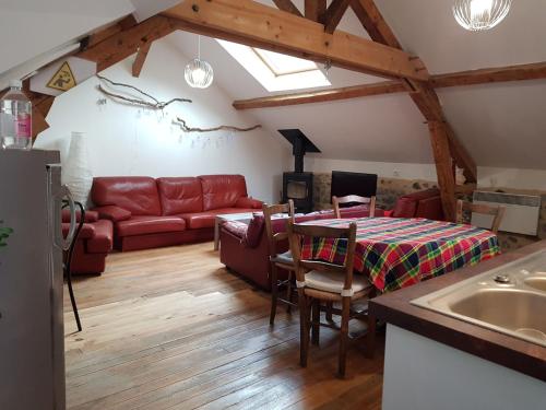 sala de estar con sofá rojo y mesa en Un petit coin d'OSSAU, en Bescat