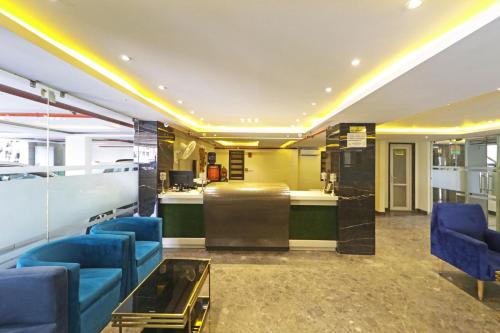 a lobby with blue chairs and a counter at The IVY Grand Hotel - 5 Minutes from Connaught Place and New Delhi Railway Station With Free Secured Parking in New Delhi