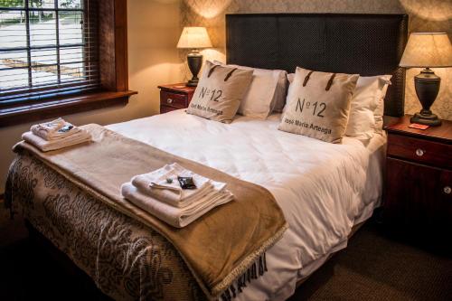 a hotel room with a bed with towels on it at Kralinbergh Estate Guesthouse in Ermelo