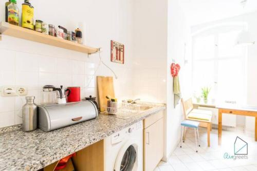 a kitchen with a sink and a washing machine at Sunny Studio at Wismarplatz in Berlin