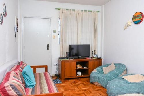 sala de estar con TV y sofá en cantinho jardim en Santos