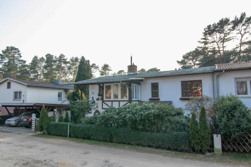 uma casa branca com uma cerca à frente. em Ferienwohnung Timmy em Lubmin