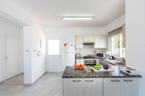 a kitchen with a counter with fruits and vegetables on it at Fig Tree Bay Villa 4 in Protaras