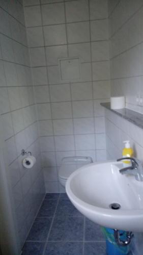 a white bathroom with a sink and a toilet at Ferienwohnung am Uferpark Blaser kleines Appartment F3 in Friedrichshafen