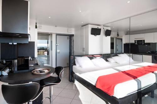 une chambre avec un lit et une table et une cuisine dans l'établissement Studio Village Naturiste Spy on me, au Cap d'Agde