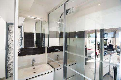 La salle de bains est pourvue de 2 lavabos et d'une paroi en verre. dans l'établissement Studio Village Naturiste Spy on me, au Cap d'Agde