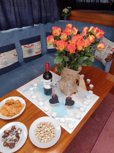 a table with a vase of flowers and a bottle of wine at Djinn Palace by Serviced Living Liverpool in Liverpool