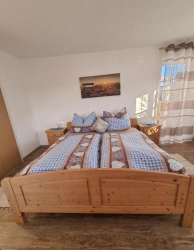 a large wooden bed in a bedroom with at Ferienwohnung BERGLIEBE in Nesselwang