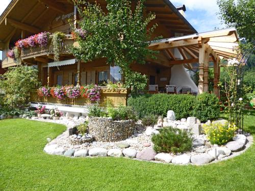 a garden in front of a house with rocks and flowers at Appartement Bergrose in Hopfgarten im Brixental