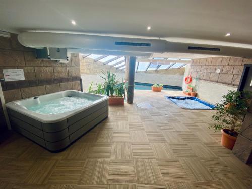 a large bath tub in a room with plants at Apartamentos Spa Casco Historico de Isla in Isla