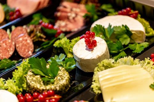 a buffet of food with cheese and meats and vegetables at Ringhotel Jägerhof in Weißenfels