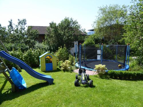 a yard with a playground with a slide and a playset at Appartement Bergrose in Hopfgarten im Brixental