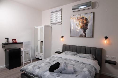1 dormitorio con 1 cama y una pintura en la pared en Luxury Room Bahai's Garden, en Haifa