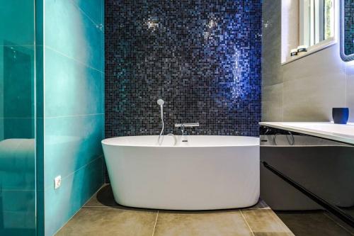 a bath tub in a bathroom with blue tiles at Luxury apartment Martinis with pool in Split