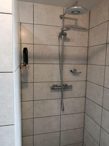 La salle de bains est pourvue d'une douche avec un pommeau de douche. dans l'établissement Pokój przy jeziorze, à Wiżajny
