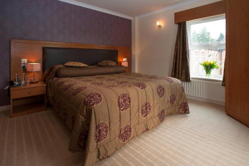 a bedroom with a large bed and a window at Burn Hall Hotel in Huby