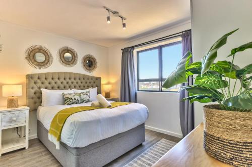 a bedroom with a bed and a potted plant at Gorgeous, central, secure- foothills of Table M! in Cape Town