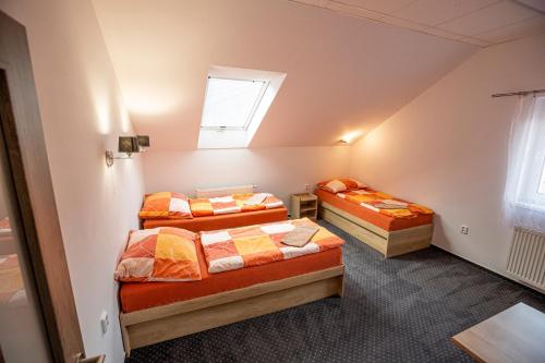 two beds in a small room with a window at Hotel Rabbit in Trhový Štěpánov