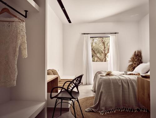 a white bedroom with a bed and a window at Sanpiero Island in Zakynthos Town