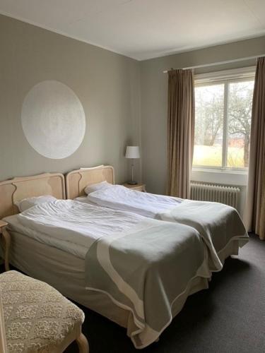 um quarto com uma cama grande e uma janela em Bruksmässen Hotell em Degerfors