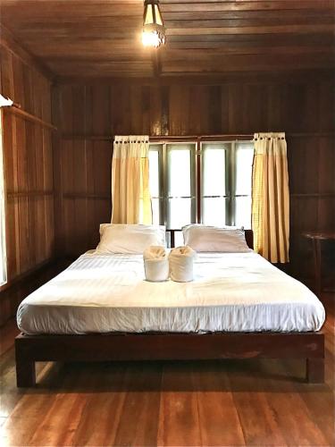 a bed with two pillows on it in a room at Frog Beach House in Ko Phayam