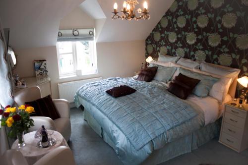 a bedroom with a bed and a couch and a chair at Y Garth Luxury Bed and Breakfast in Newport Pembrokeshire