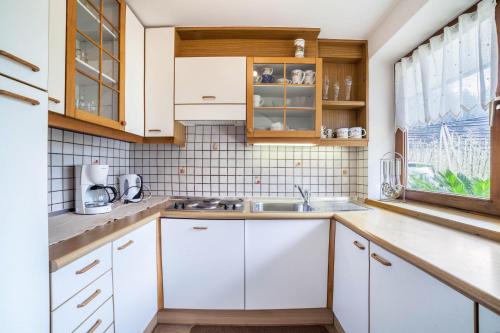 a kitchen with white cabinets and a sink at Masulhof Ferienwohnung Löwenzahn in Verdines