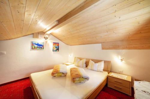 a bedroom with two beds in a room with wooden ceilings at Masulhof Ferienwohnung Flieder in Verdines