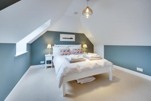 - une chambre avec un lit blanc aux murs bleus dans l'établissement Super 5 Bedroom Family Friendly Retreat Rustington, à Littlehampton