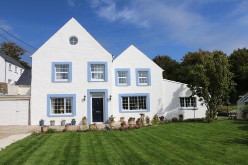 a white house with a green lawn at Ty Nant Little Haven in Little Haven