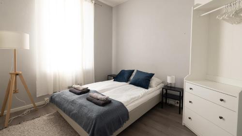 een kleine slaapkamer met een bed en een dressoir bij 2ndhomes Modern & Central 1BR Top Floor home in Helsinki