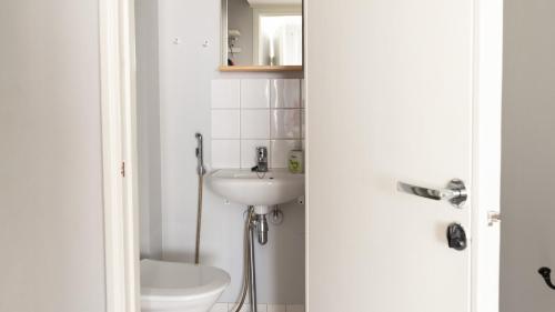 een badkamer met een wastafel en een toilet bij 2ndhomes Modern & Central 1BR Top Floor home in Helsinki