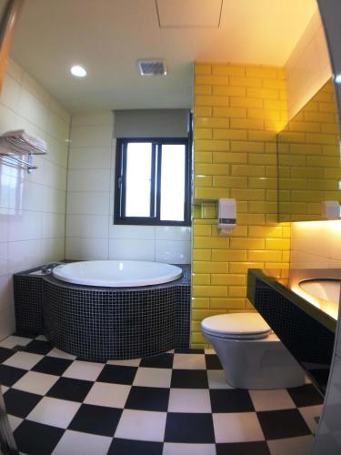 a bathroom with a tub and a toilet and a sink at CoCo Motel Boutique in Puli