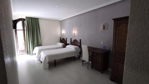 a bedroom with two beds and a dresser in it at Emperatriz II in Salamanca