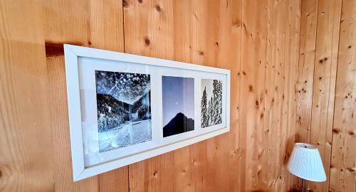 a picture hanging on a wooden wall with a lamp at Haus Emmy - Urlaub bei Freunden in Hohentauern