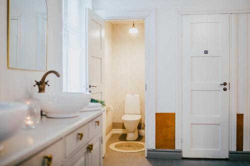 a bathroom with a sink and a toilet at Salaisen Puutarhan Majatalo in Kauhajoki