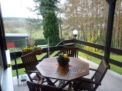 a wooden table and chairs on a balcony with a view at Ferienhaus "Hauß" Objekt ID 12063-3 in Waren