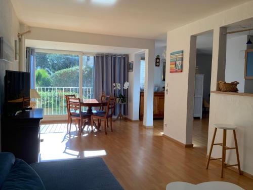 un salon avec une table et des chaises et un balcon dans l'établissement La forlane, à Cassis