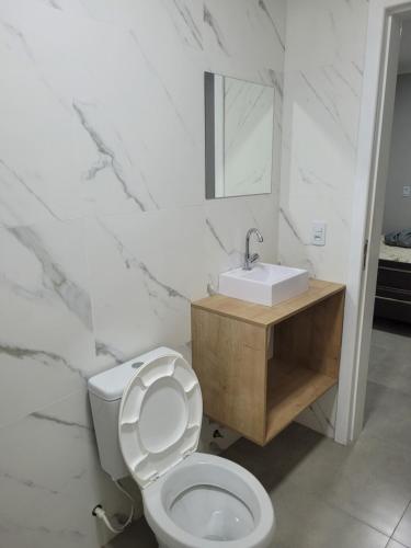 ガロパバにあるNOVO LAR GAROPABA 2の白いバスルーム(トイレ、シンク付)