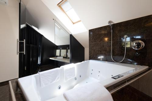 a large white bath tub in a bathroom at Hotel TraumVogel in Jennersdorf