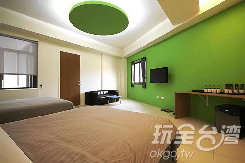 a bedroom with a bed and a green wall at CoCo Motel Boutique in Puli