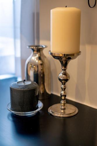 a candle on a table next to a candlestick with a candle gmaxwell gmaxwell at Triple A - Prime Location - Between Monastiraki & Syntagma Square-FREE Parking! in Athens