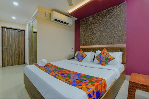 1 dormitorio con 1 cama grande con una manta colorida en FabHotel Middleton Desire, en Bhubaneshwar